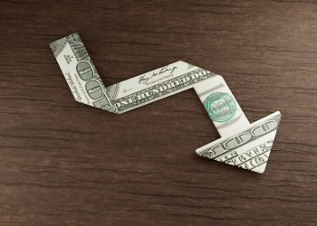 U.S. dollar bill points downward, symbolizing the decline in the dollar's dominance, particularly in the Middle East.